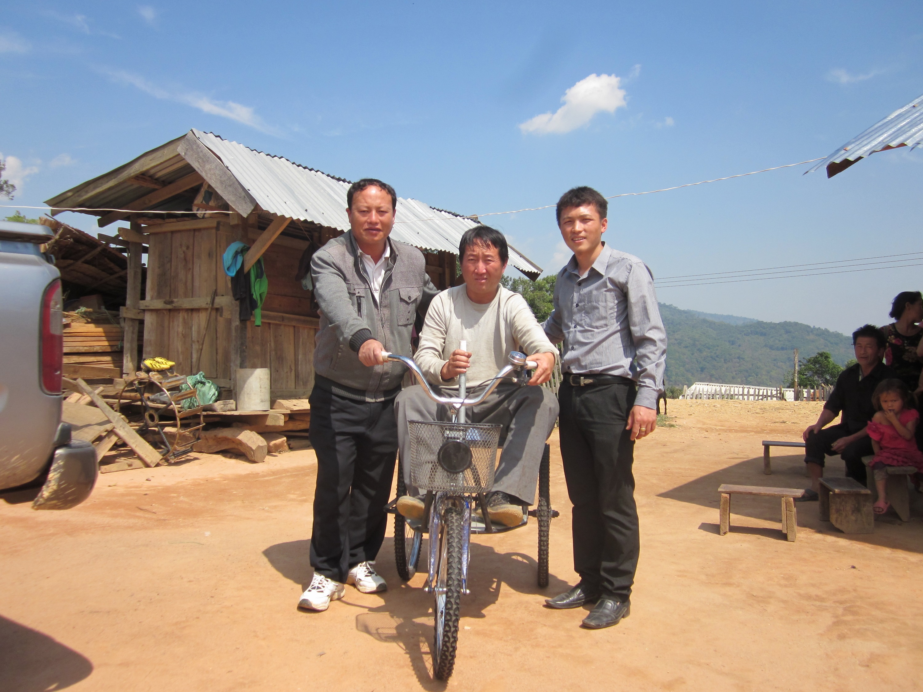 VAST and the Xieng Khouang Provincial Rehabilitation Center deliver a tricycle to Yae Lee who is bilateral leg amputee in Phoukoud district.