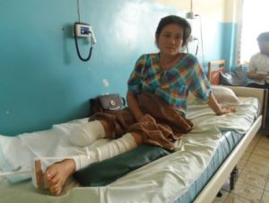 UXO survivor Ms. Bouakham sitting upright in hospital bed