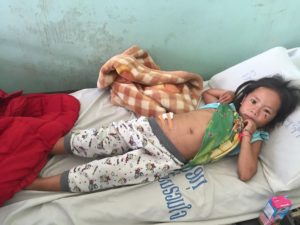 young girl injured by UXO accident in hospital bed